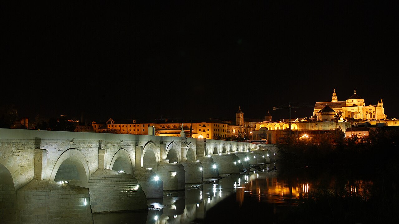 Puente romano y Mezquita-Catedral de Córdoba iluminados de noche.